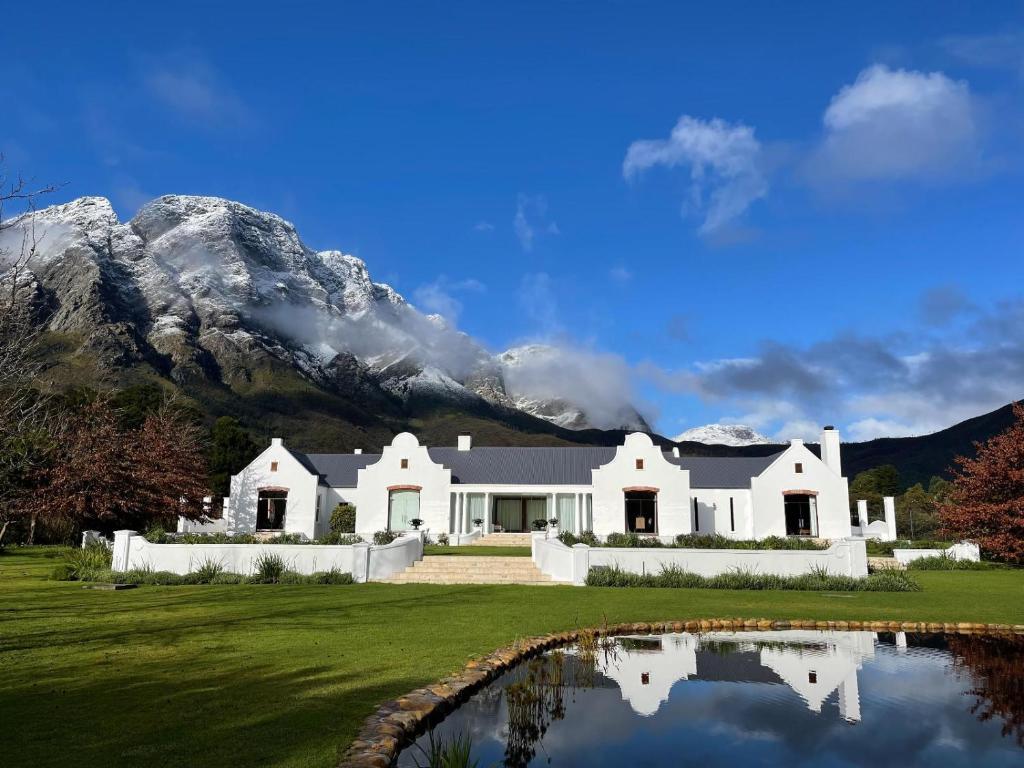 a white house with a mountain in the background at Chambray Estate - The Terraces in the Vines in Franschhoek