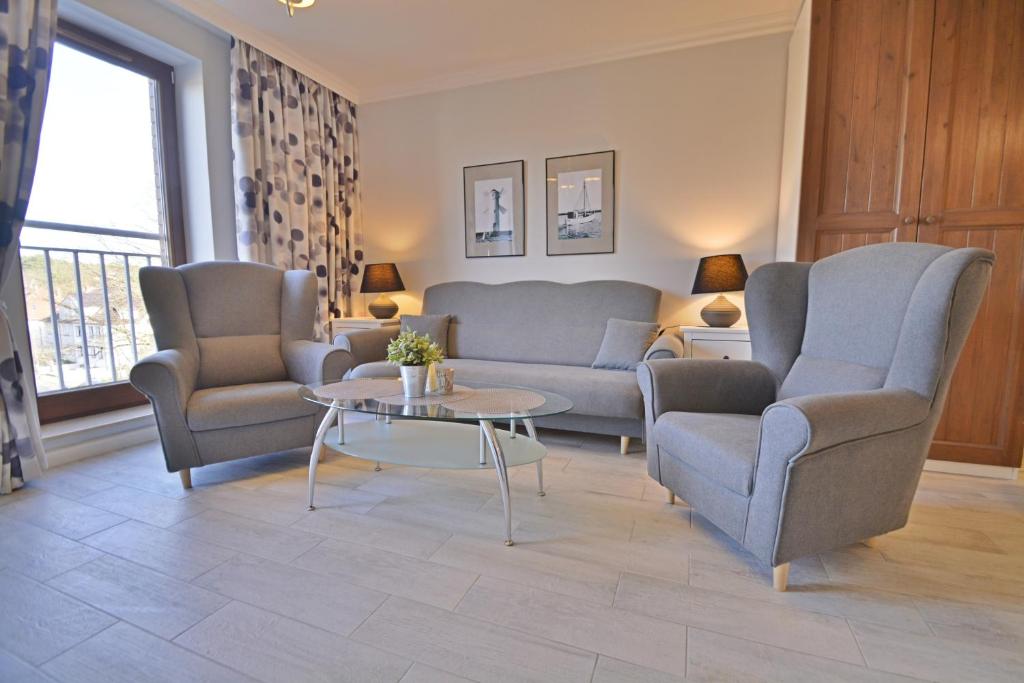 een woonkamer met twee banken en een tafel bij Osiedle Platan - Apartamenty Bryza - Centrum in Świnoujście