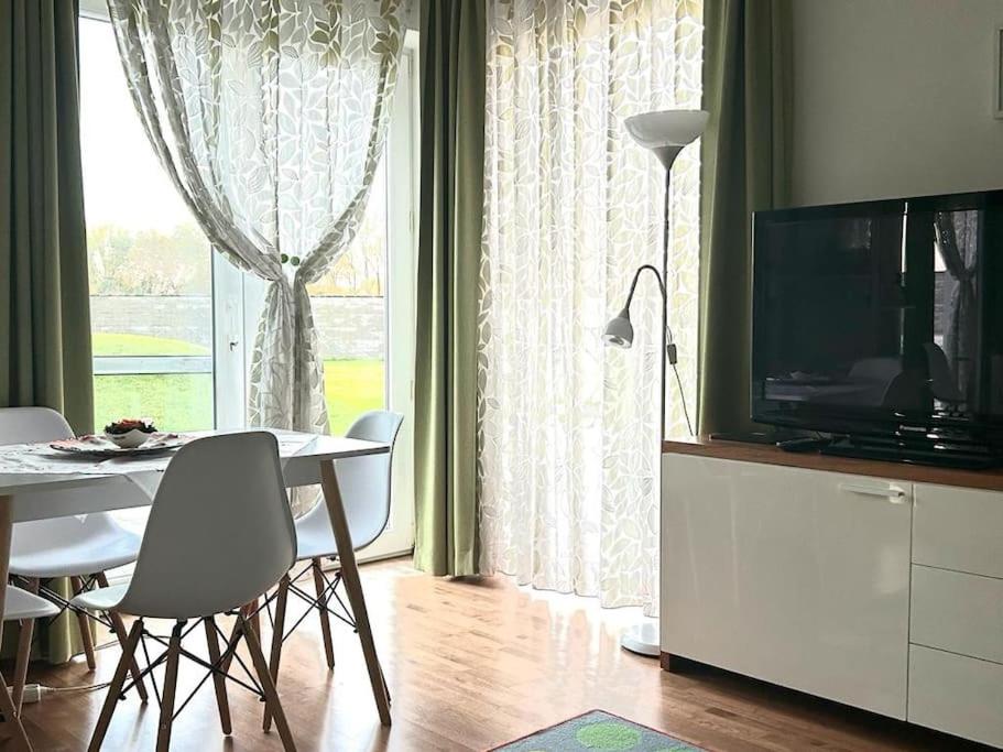 een woonkamer met een televisie en een tafel en stoelen bij Apartman pri X Bionic Sphere Samorin s vínnou pivnicou in Blatná na Ostrove