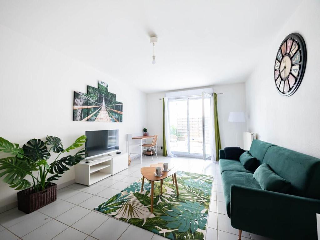 un salon avec un canapé vert et une table dans l'établissement Le Messidor - Terrasse Rives du Lez, à Montpellier