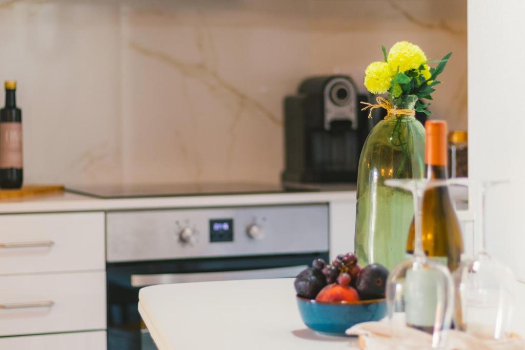 a kitchen counter with a vase with flowers and fruit at CASAS DA RUA NOVA in Alijó