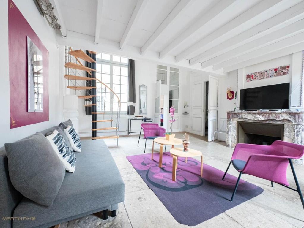 un salon avec un canapé et une cheminée dans l'établissement Le pianiste - Climatisation en coeur de ville, à Montpellier