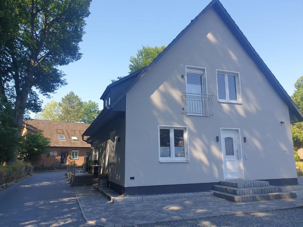 uma casa branca com um telhado preto em likehome Suite em Buchholz in der Nordheide