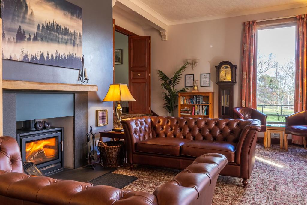 a living room with a couch and a fireplace at Crubenbeg Country House in Newtonmore
