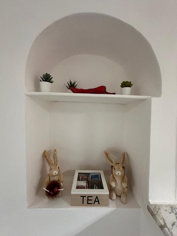 a shelf with two rabbits and a tea book at La casa di Stella in Isernia