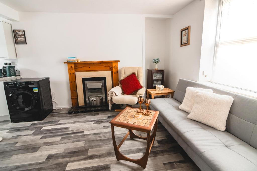 a living room with a couch and a fireplace at A Perfect 1BD Getaway in Aberdare, South Wales in Aberdare