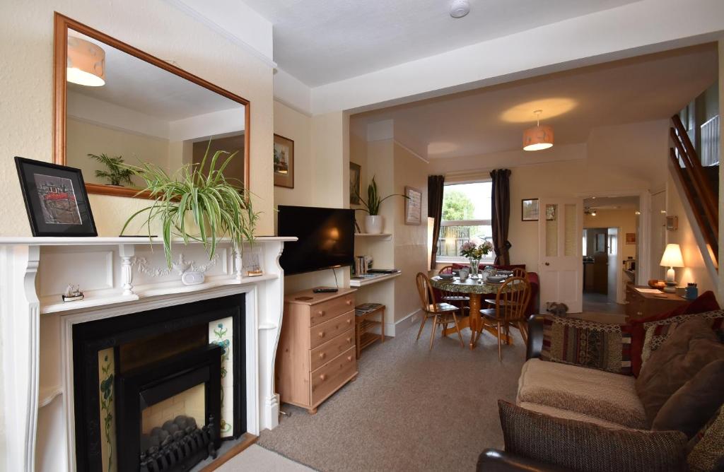 a living room with a fireplace and a dining room at Tilling View with private parking in Rye