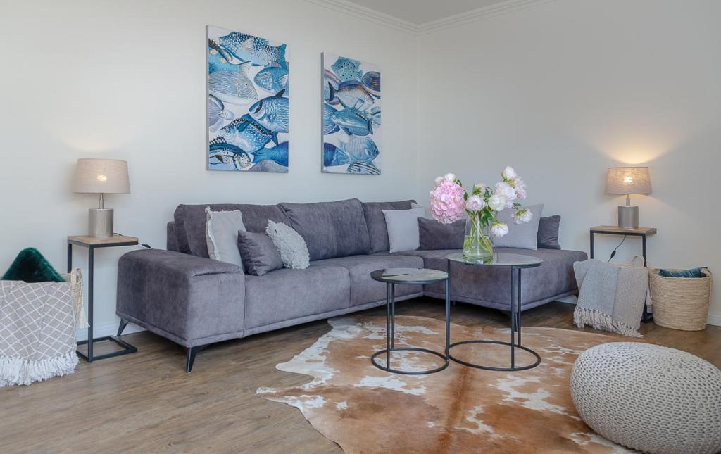 uma sala de estar com um sofá e uma mesa com flores em Ferienwohnung Königsmann in Strandnähe em Westerland