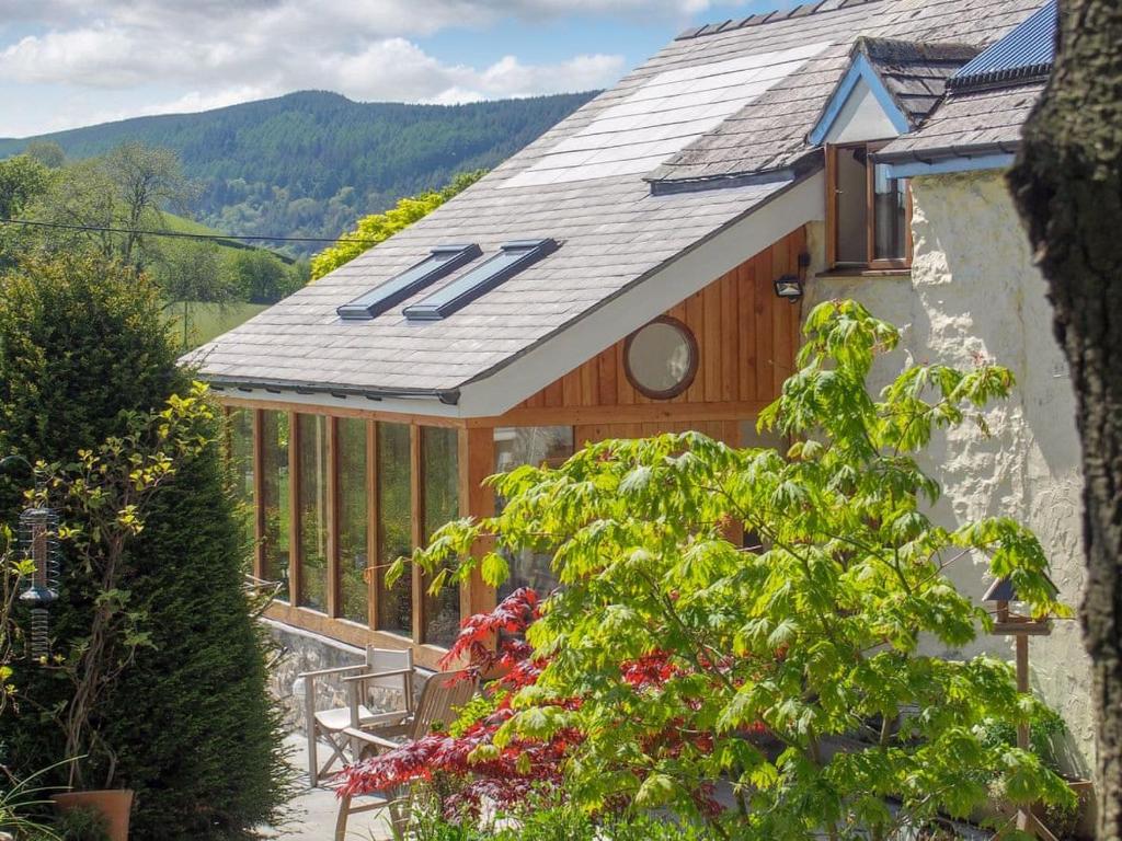 una casa con techo, mesa y ventana en Hafotty Fach, en Llanfyllin