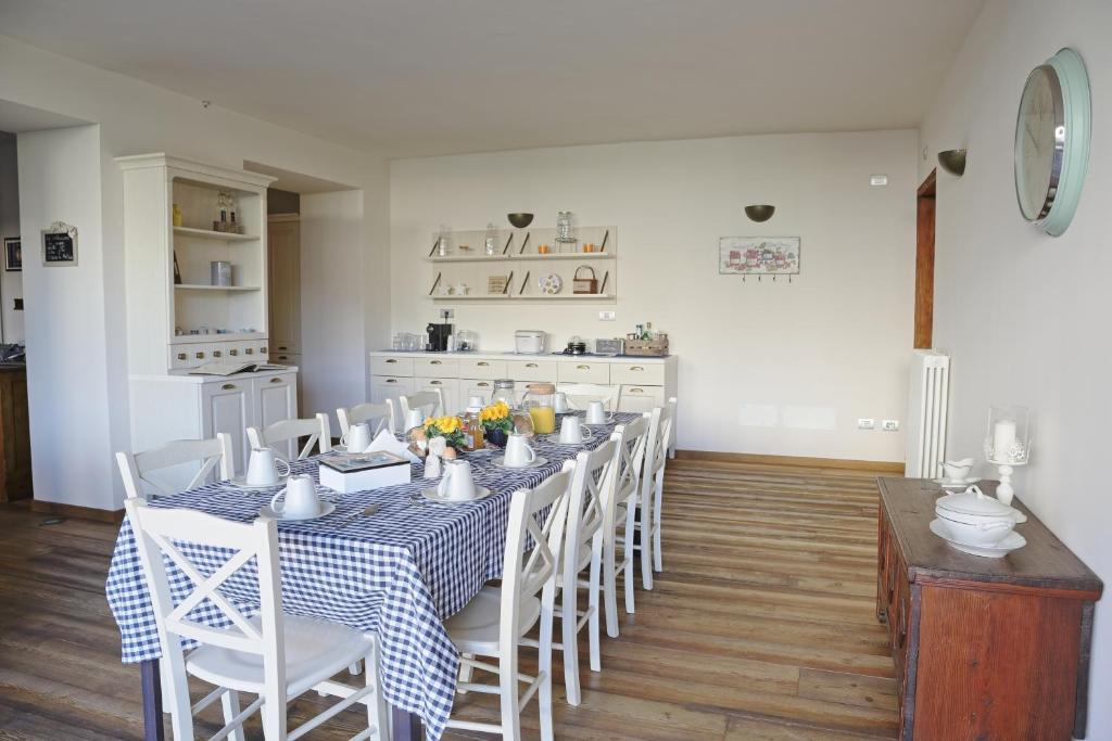 uma sala de jantar com uma mesa e cadeiras azuis e brancas em La Corte di Nonna Gemma - Holiday Home em Delebio