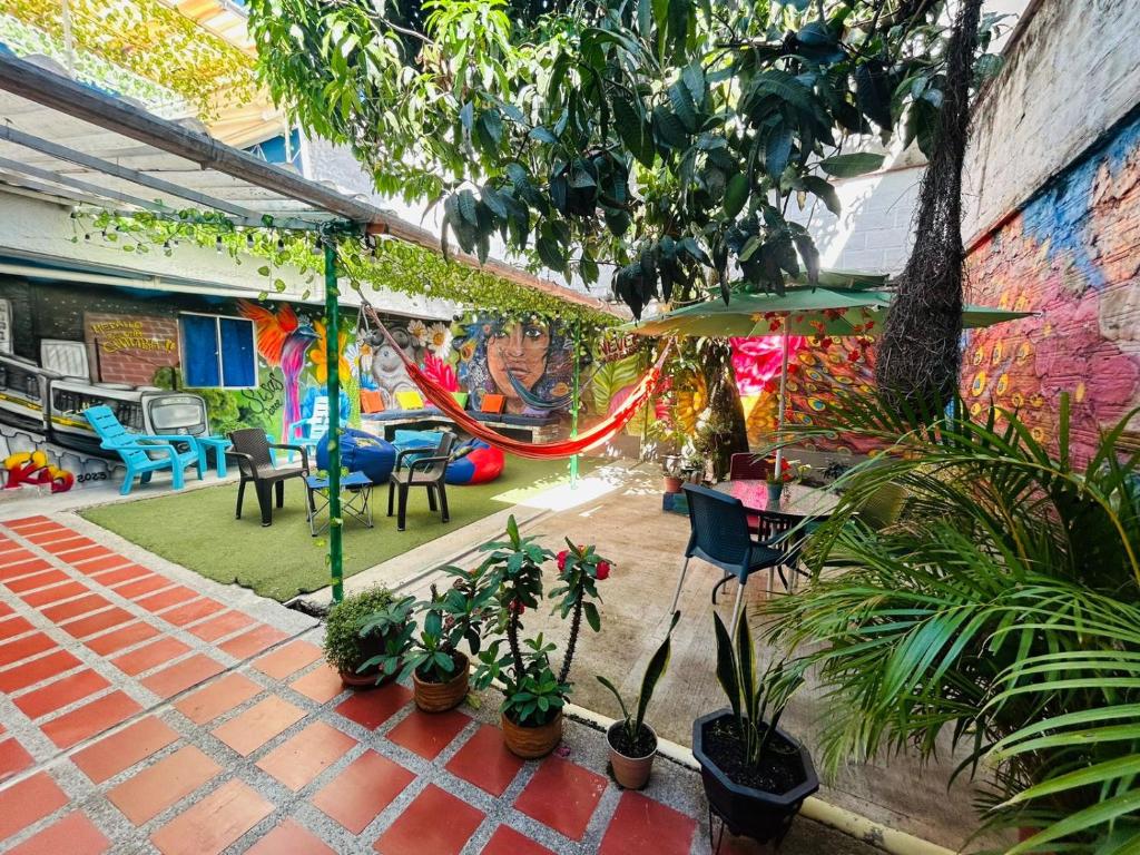 a patio with plants and tables and a mural at Blue Coast Hostal in Medellín