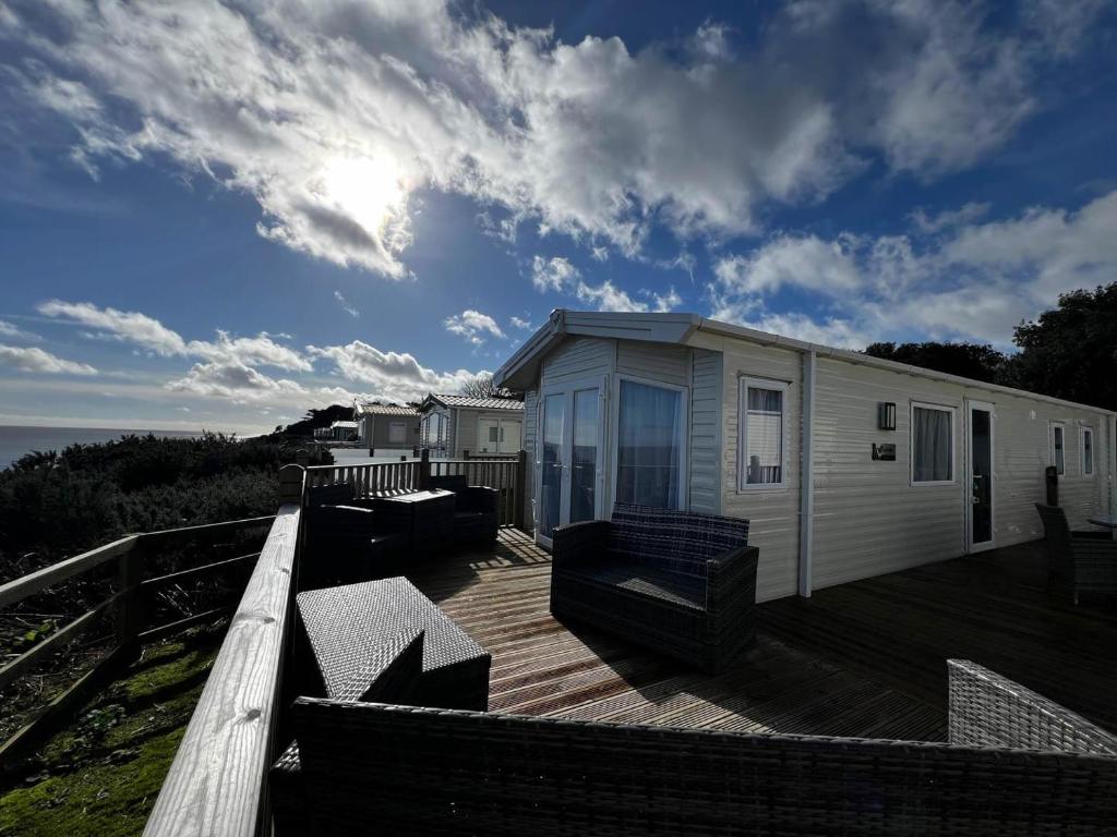 a house on a deck with a view of the ocean at 6 Berth Caravan With Stunning Sea Views And Decking To Relax On, Ref 32048az in Lowestoft