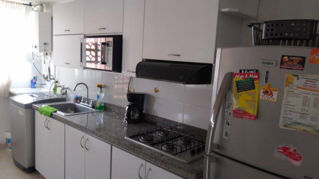 uma cozinha com um frigorífico e um lavatório em APARTAMENTO VILLA OLÍMPICA em Pereira