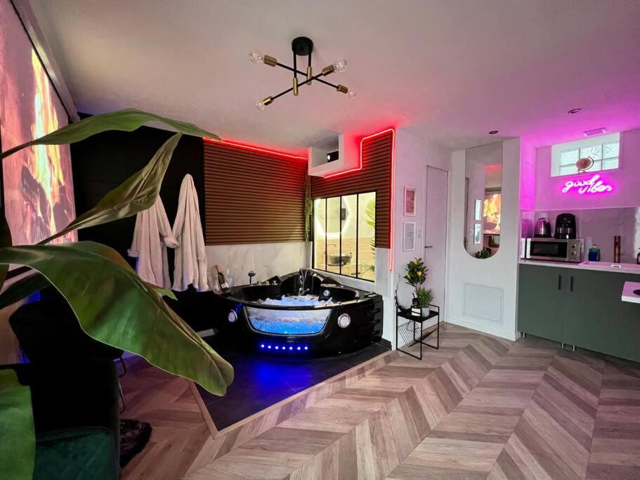 baño con bañera grande con luces moradas en Black Love-room - Balnéo - Cinéma en Souppes-sur-Loing