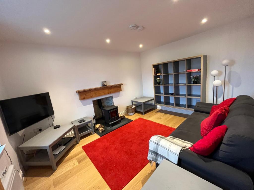 ein Wohnzimmer mit einem Sofa und einem Kamin in der Unterkunft Alt-Na-Slat Cottage in Invergarry