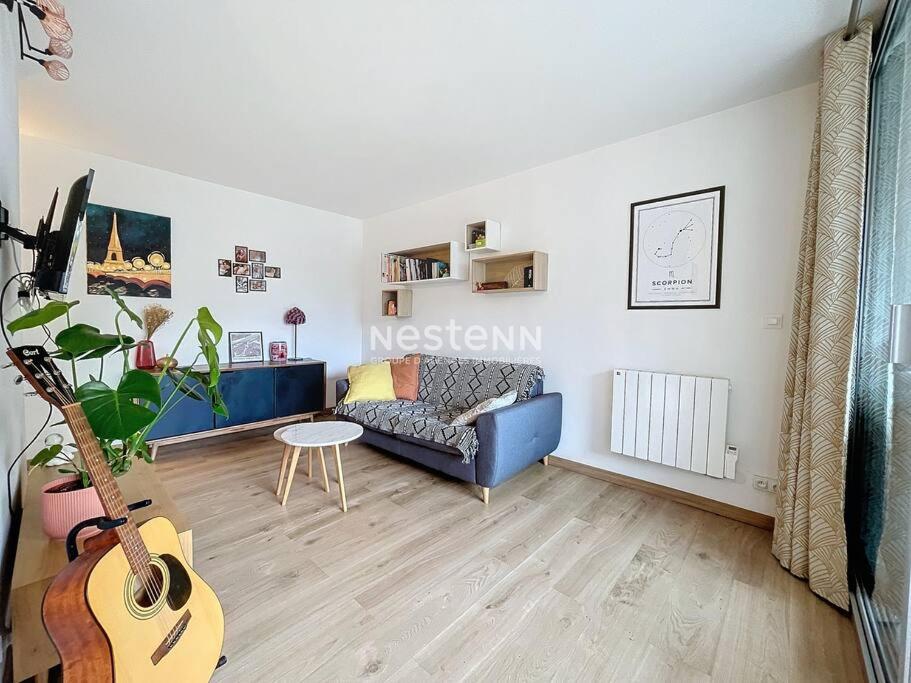 - un salon avec un canapé bleu et une guitare dans l'établissement APPA3255-T2 à 400m de la plage, à Argelès-sur-Mer