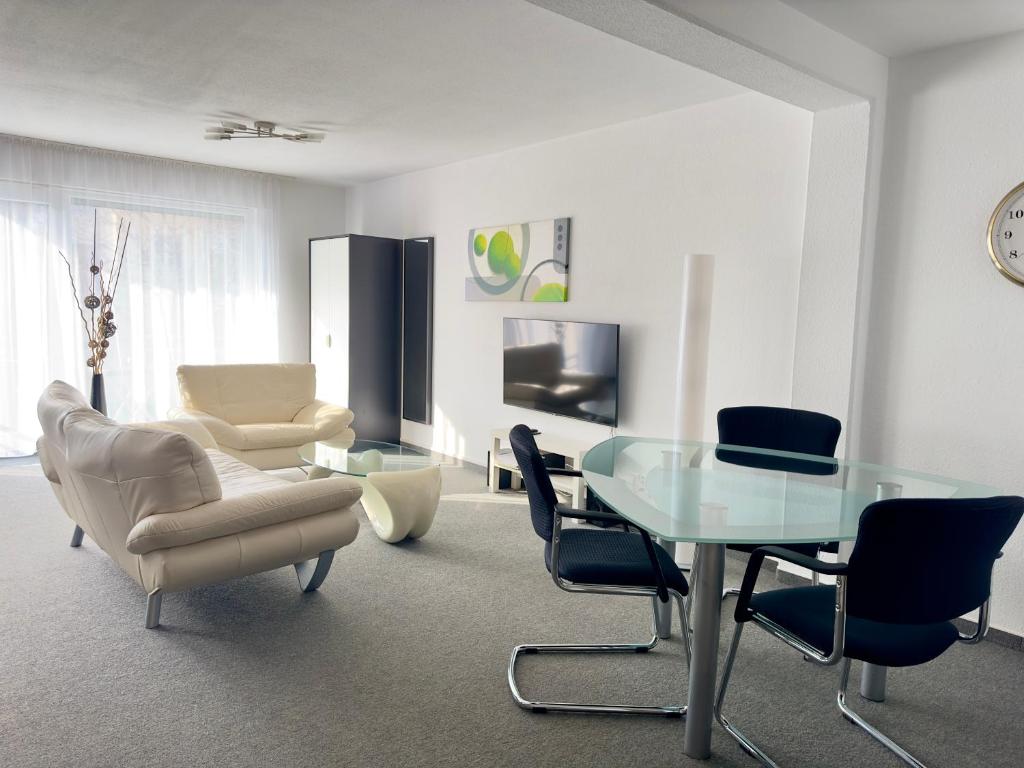 sala de estar con mesa de cristal y sillas en Ferienwohnung Sonitschka en Lörrach