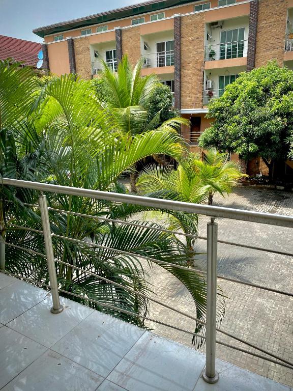 a fence with palm trees in front of a building at Executive suite escape in Lekki