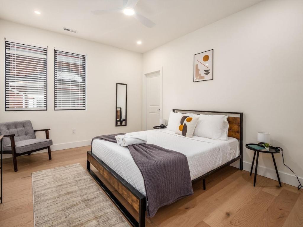 a white bedroom with a bed and a chair at Modern Luxury 4BR 3 5BA Oasis in Historic Old Town East PD in Columbus