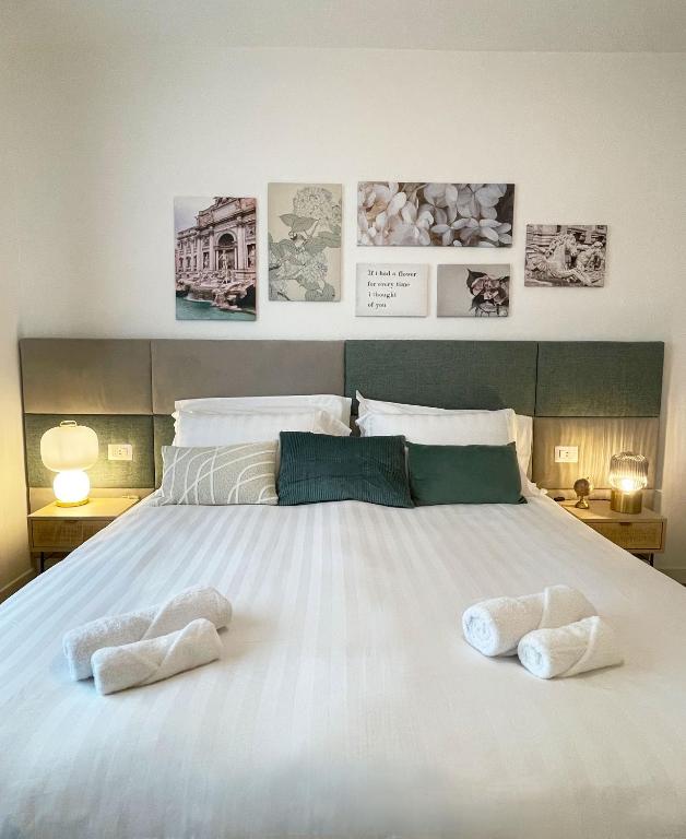 a large white bed with two white towels on it at B&B Domus Teano Luxury Rooms in Rome