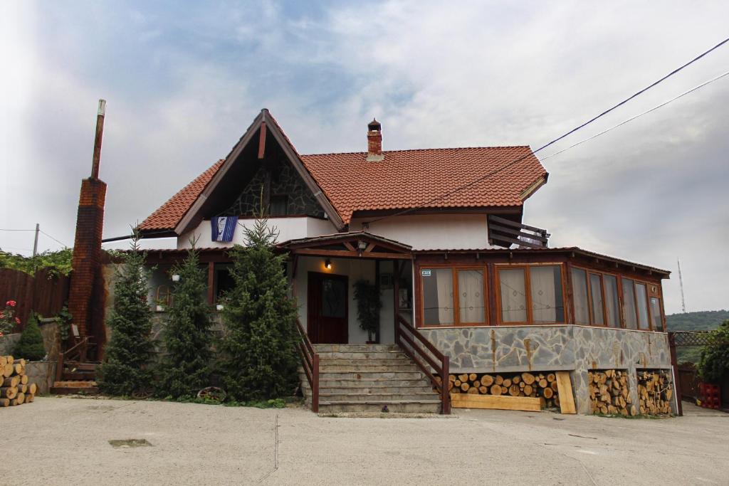 a white house with a red roof at Pensiunea Taverna Bucium in Iaşi