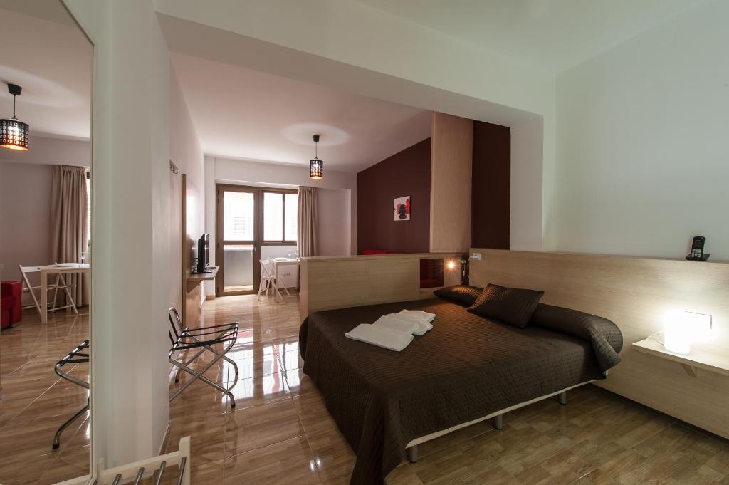 a bedroom with a bed and a living room at Las Palmas Urban Center in Las Palmas de Gran Canaria