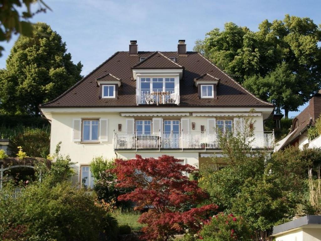 Großes weißes Haus mit Balkon in der Unterkunft Ferienwohnung Bodenseeblick in Allensbach