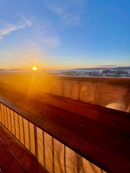 d'un balcon avec une clôture offrant une vue sur le coucher du soleil. dans l'établissement Appartement rénové avec balcon à La Joliette, à Marseille
