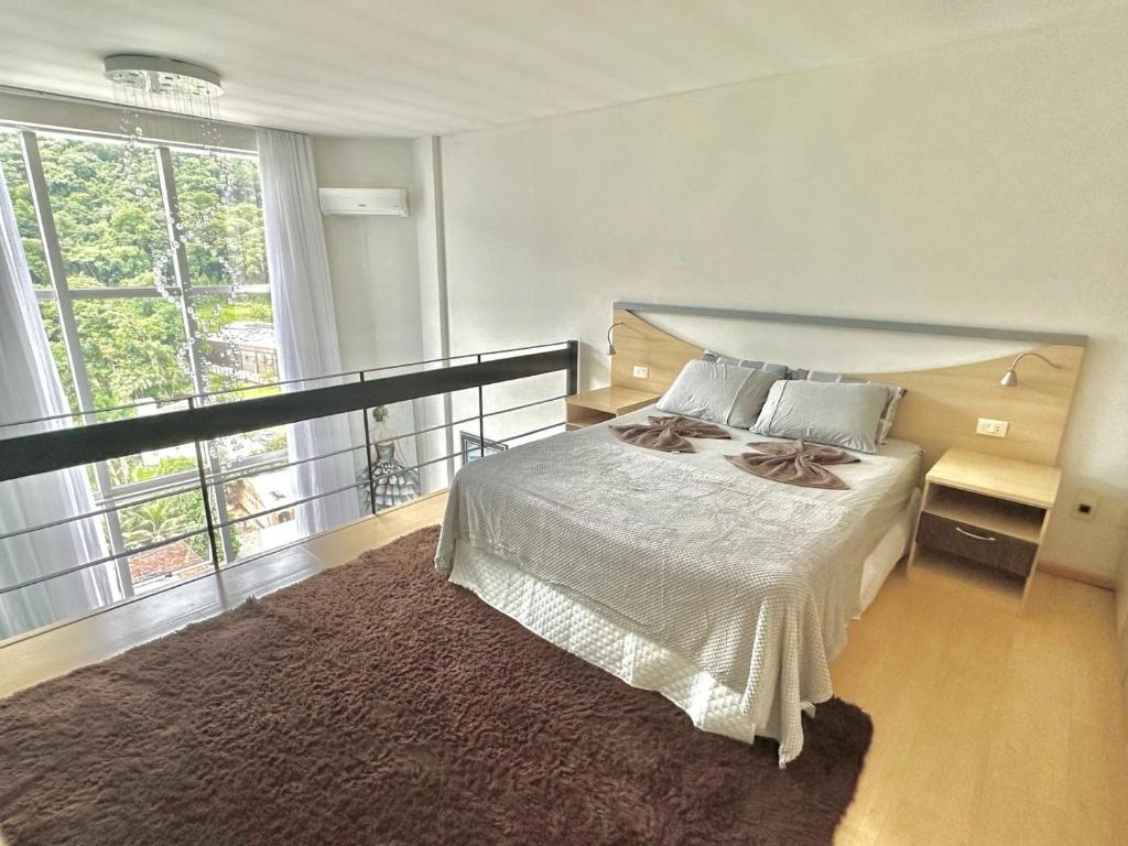 南雅拉瓜Saint Sebastian Flat 603- Com Hidro! até 3 pessoas, Duplex, no centro的一间带床和大窗户的卧室