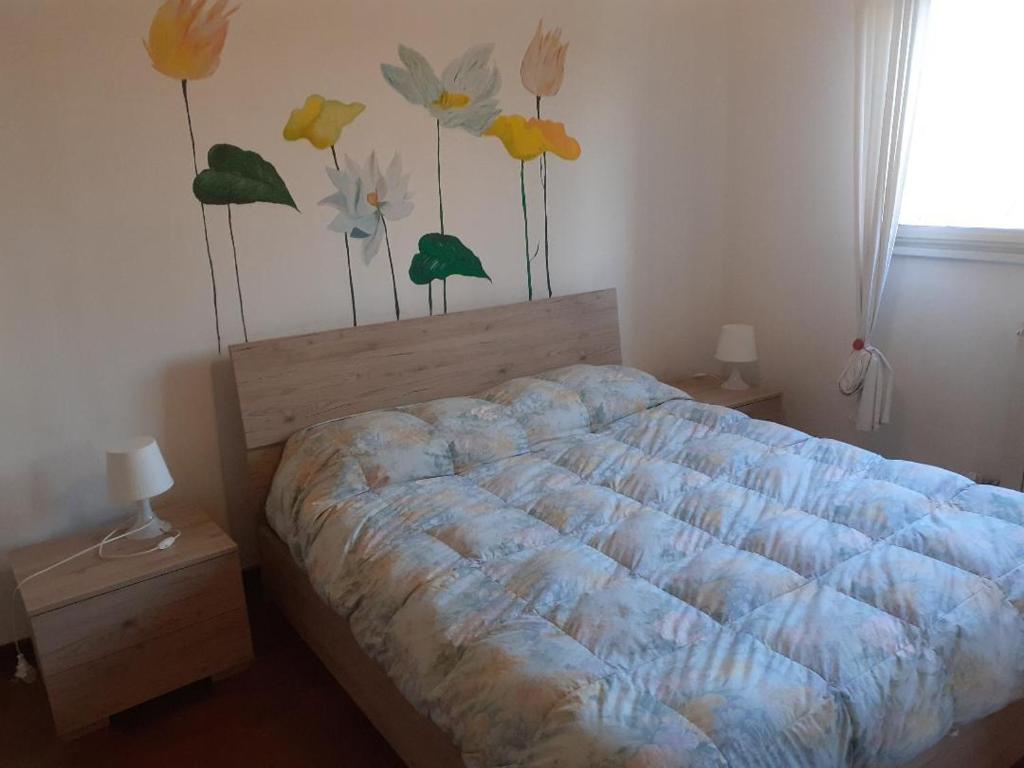 een slaapkamer met een bed met een bloemschilderij aan de muur bij La Casa di Boh, vicino ospedale San Paolo, Iulm, Forum Assago in Milaan