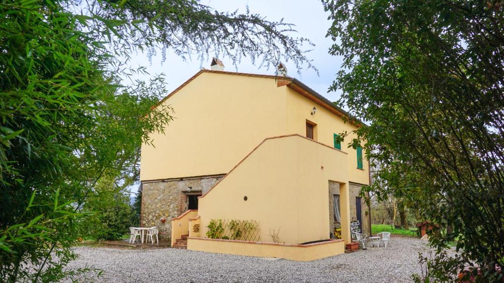 un gran edificio amarillo con mesas y sillas delante de él en Seme di Luna en Canneto