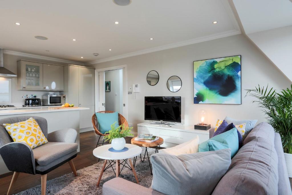 un soggiorno con divano e sedie e una cucina di Madison Hill - White Hill House 5 - 3 bedroom flat a Londra