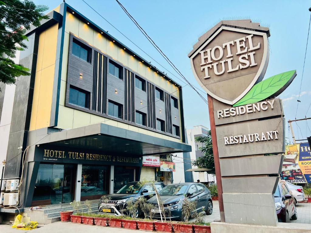 un hotel con un cartel frente a un edificio en Hotel Tulsi Residency en Bhuj