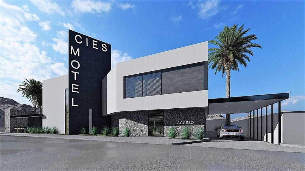 墨西卡利的住宿－MOTEL CIES，一座带有标志和棕榈树的建筑