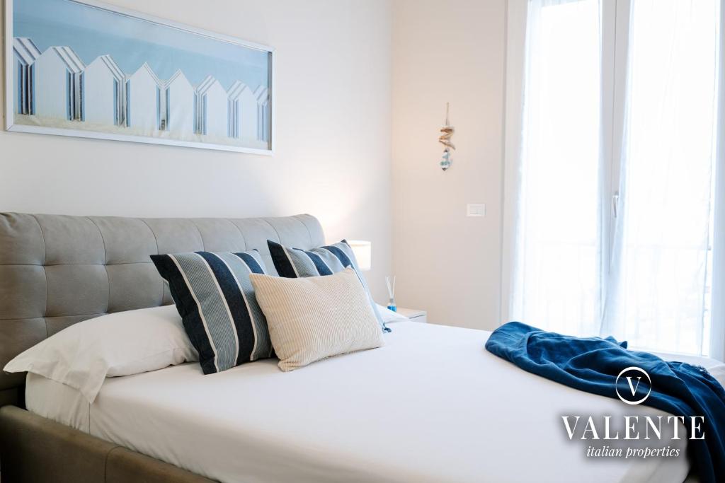 ein Schlafzimmer mit einem großen weißen Bett mit Kissen in der Unterkunft Viareggio - Via Pisano 61 Valente Italian Properties in Viareggio
