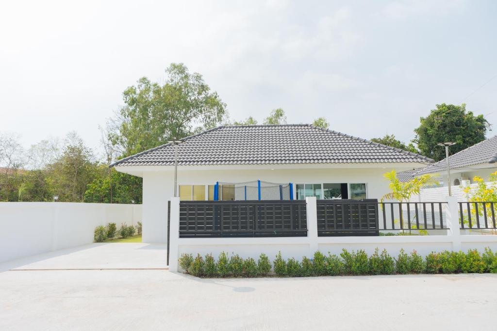 ein weißes Haus mit einem weißen Zaun in der Unterkunft Private 3BR Pool House Near Pattaya Beach in Ban Huai Yai
