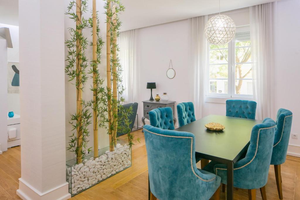 a dining room with a table and blue chairs at Apartament with a terrace in the heart of Lisbon, 300 in Lisbon