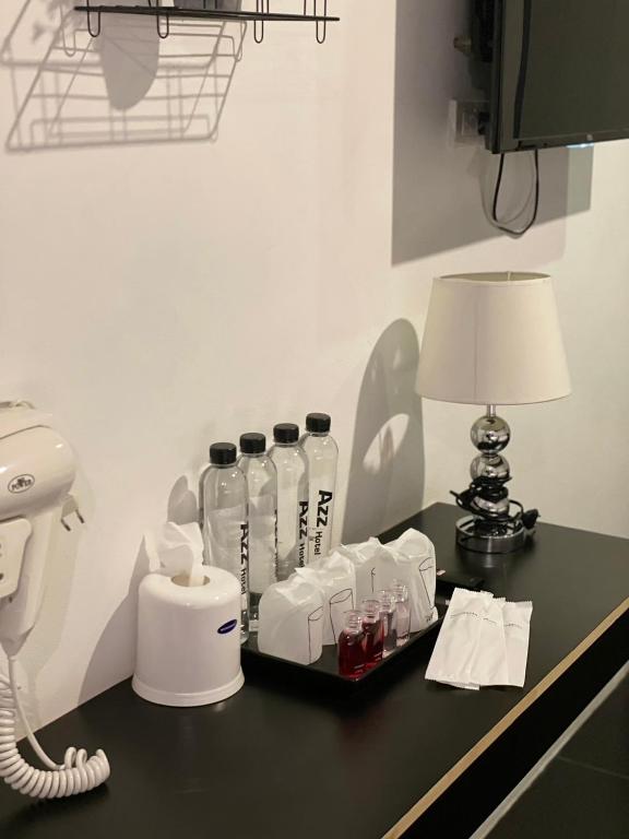 A black room console stocked with water, drinks, a kettle and a telephone.