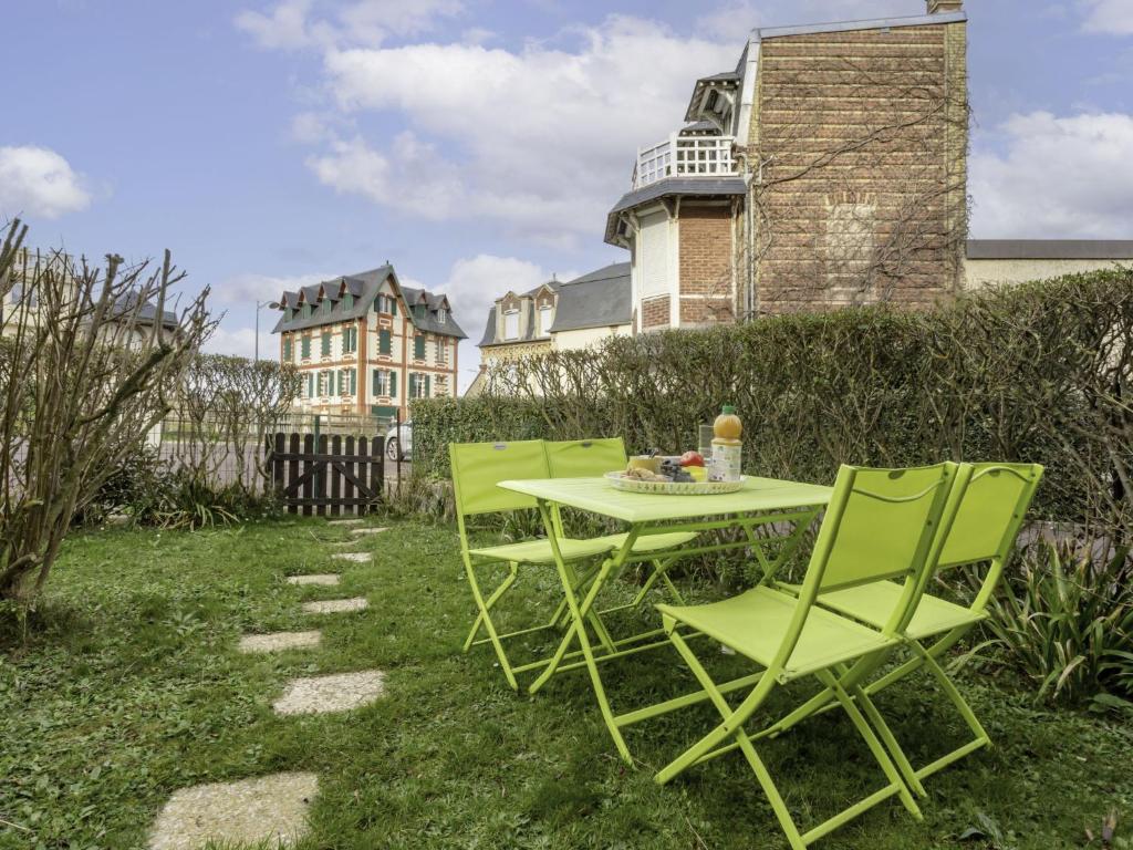 - deux chaises vertes et une table en face d'une maison dans l'établissement Apartment Le Vert Clos by Interhome, à Villers-sur-Mer