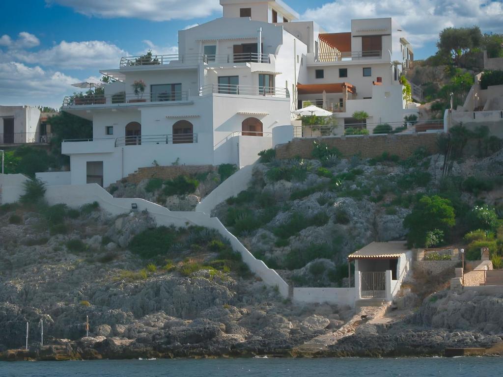 una casa bianca su una collina vicino all'acqua di Apartment La Rosa-4 by Interhome a Plemmirio