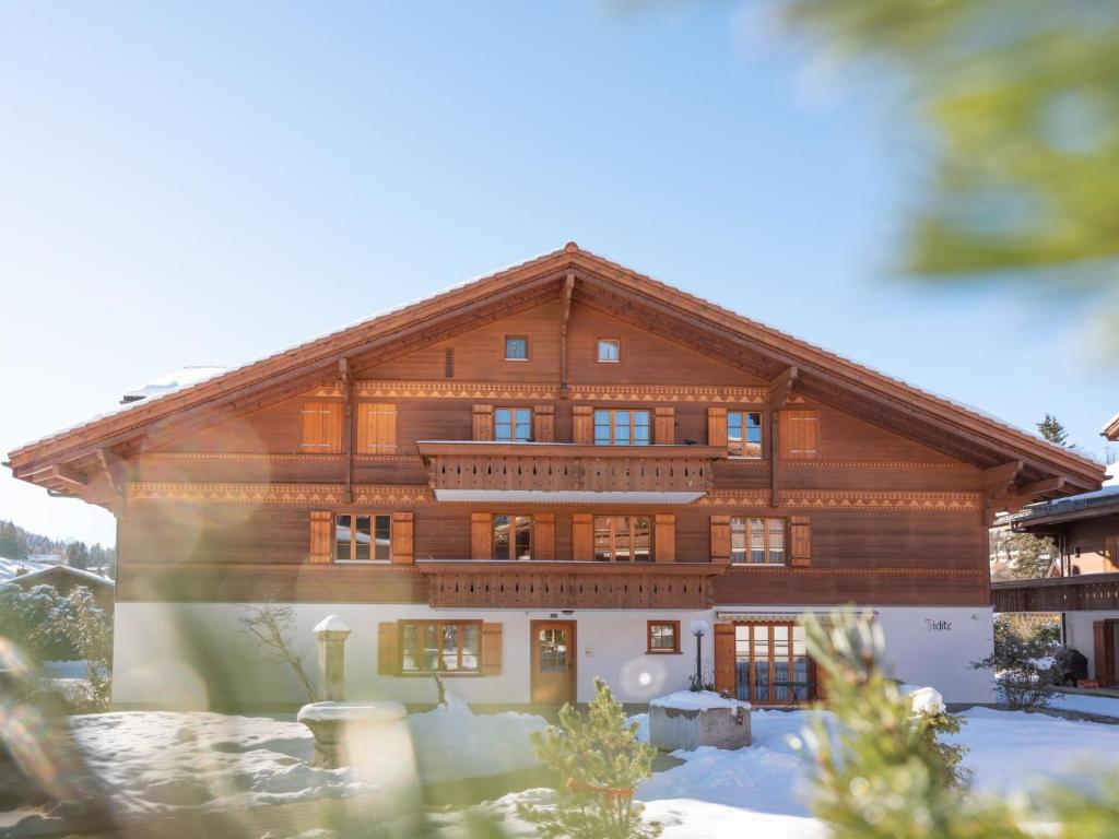 een groot houten huis met sneeuw ervoor bij Apartment Fichte - Marija by Interhome in Saanenmöser