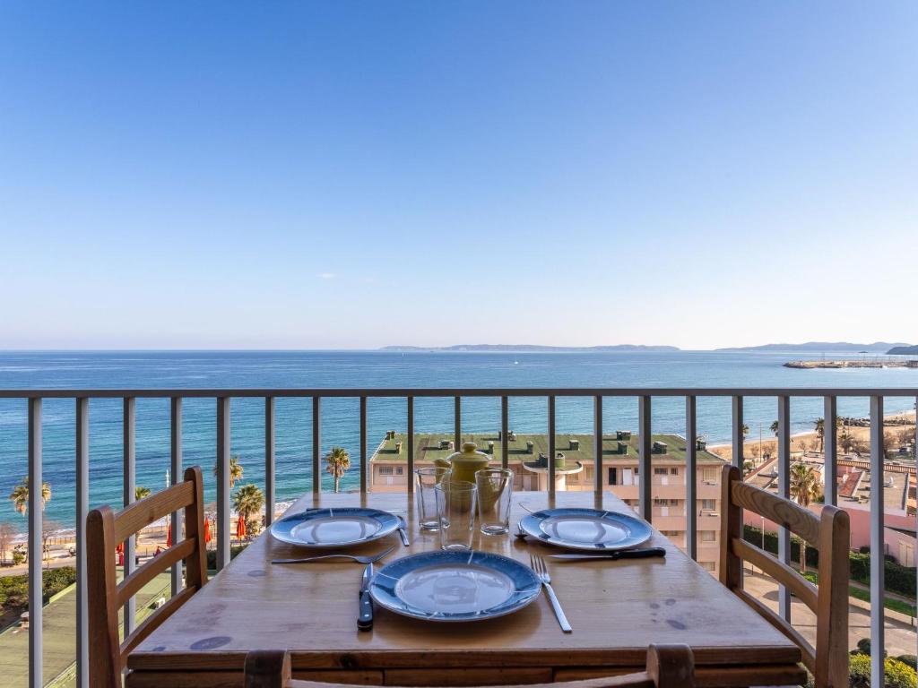 une table sur un balcon avec vue sur la plage dans l'établissement Studio Les Horizons-7 by Interhome, au Lavandou