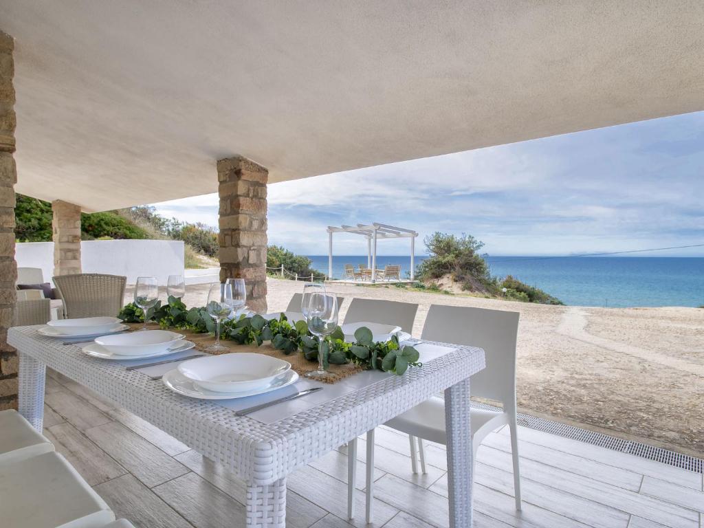 Biały stół z widokiem na plażę w obiekcie Villa Chicca by Interhome w mieście Badesi