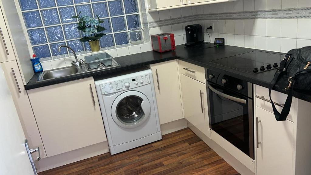 a kitchen with a washing machine and a sink at Fernando flats in London
