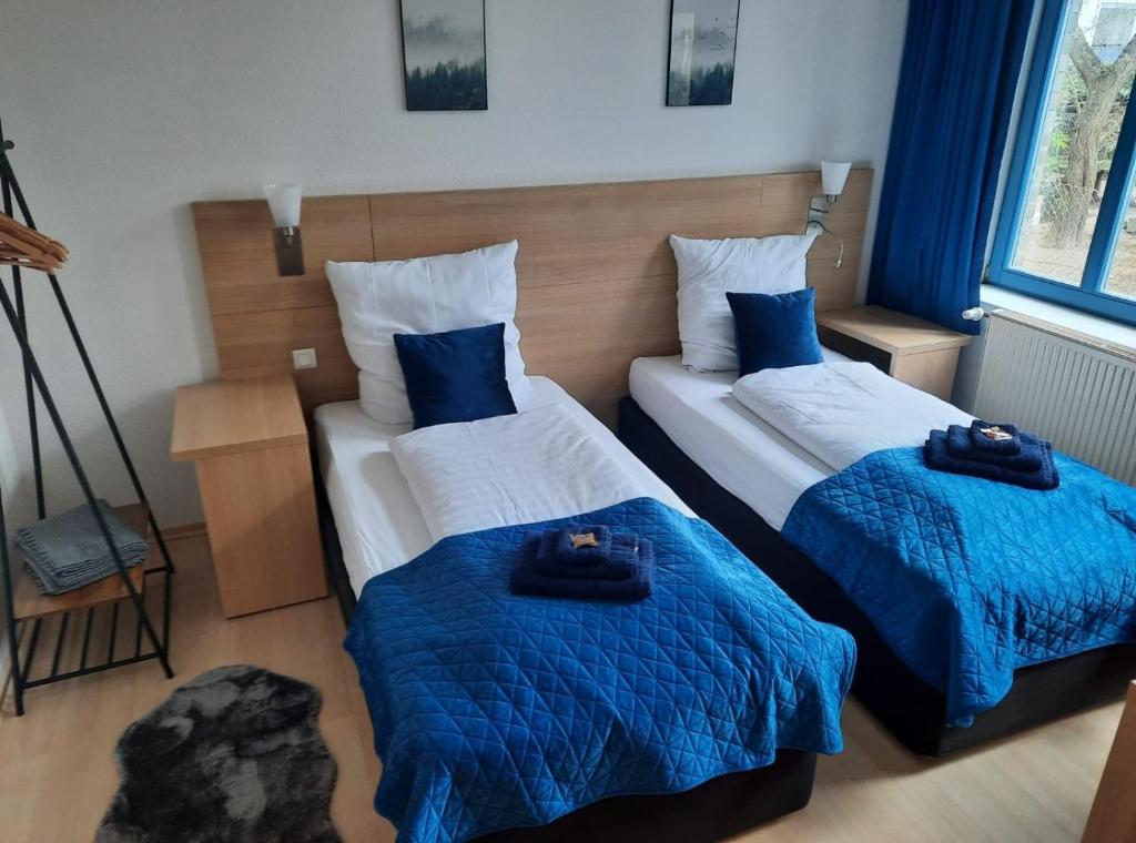 two beds in a room with blue and white at Fine Living - Einzeln oder größere Gruppen- 5 Zimmer je mit eigenem Bad - Küche - Aufenthaltsraum - bis 8 Personen in Meine