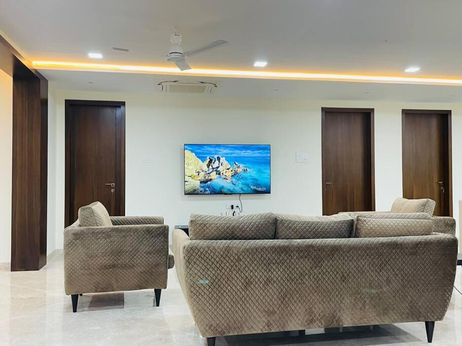 a living room with two couches and two chairs at Ultra stylish 3bhk & home theatre room in Hyderabad