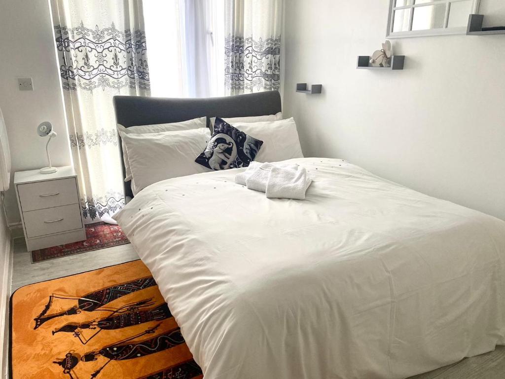 a bedroom with a large white bed with a window at Norwich Apartment - Cosy & Comfortable 1 Bedroom in Goodmayes