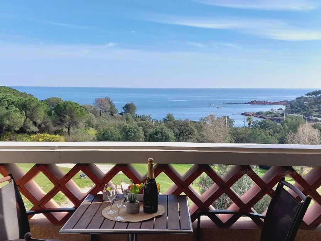 une table avec des bouteilles de vin et des verres sur un balcon dans l'établissement Apartment Le Belvédère - D4 256 by Interhome, à Agay