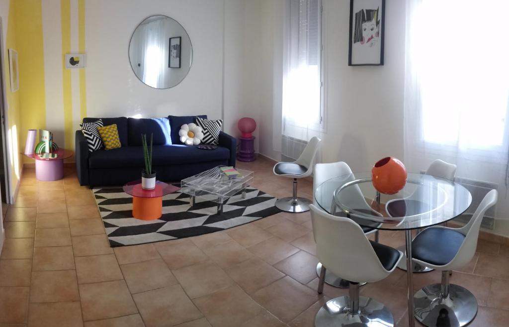 een woonkamer met een bank en een tafel en stoelen bij Appartement Avignon Centre ville intra muros in Avignon