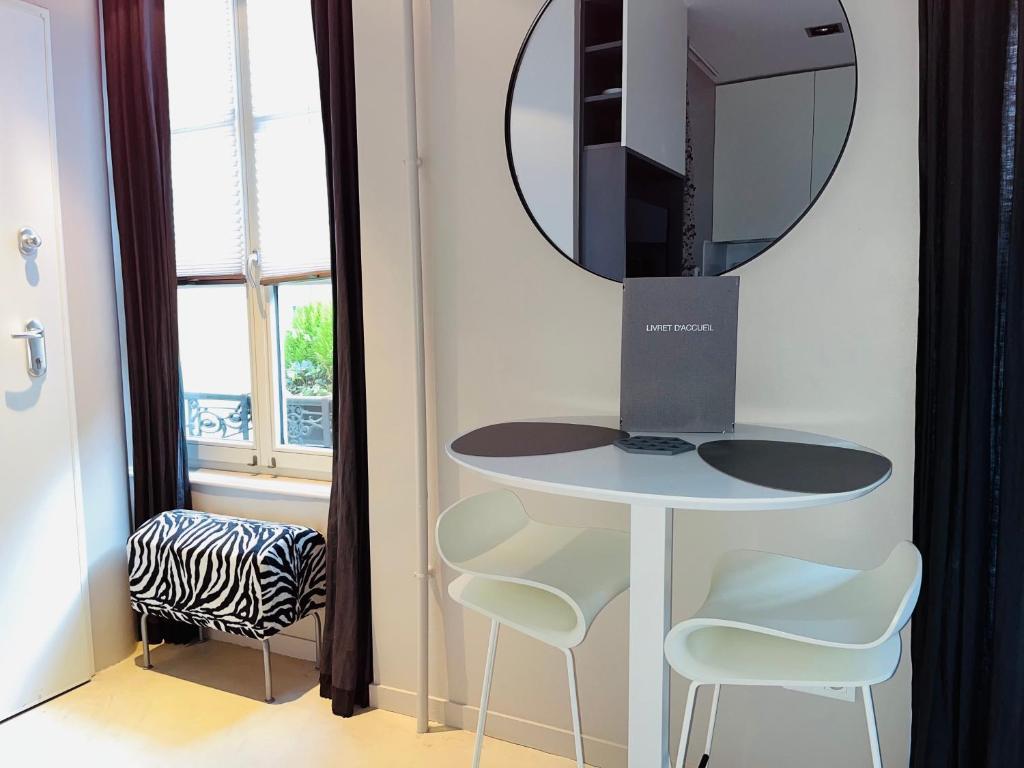 ストラスブールにあるStudio design Nuée bleue tout équipé centre villeのテーブル、鏡、椅子が備わるお部屋